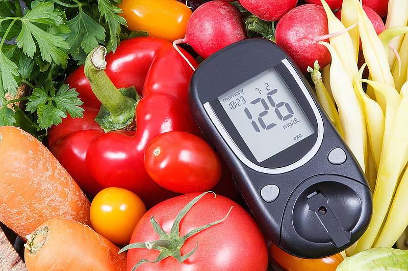 Glucometer with fresh vegetables as source minerals and vitamins. Diabetes, healthy lifestyles and dieting Blutzuckermessgerät in einem Korb mit Gemüse liegend